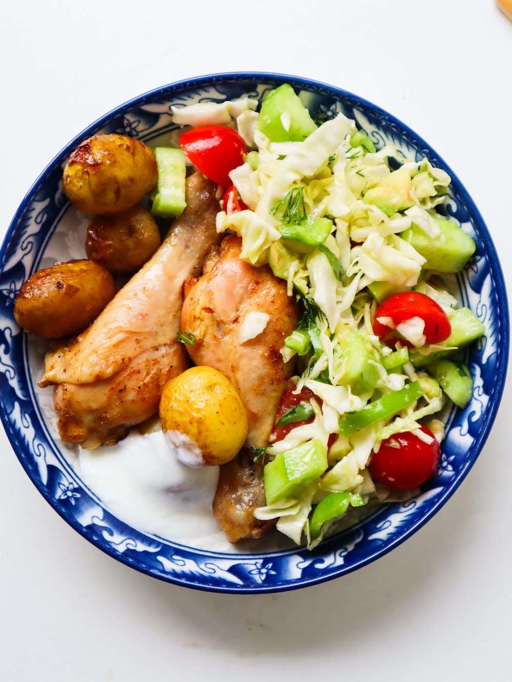 Looking for meal prep friendly healthy chicken dinner recipes that make themselves? This recipe for easy baked chicken drumsticks with potatoes is what you need.